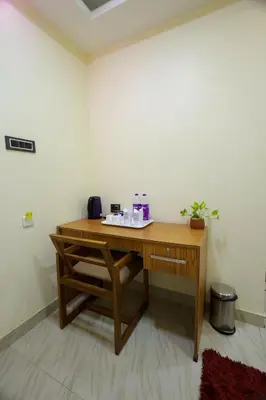 a wooden desk in a corner of a room at Builda Park inn in Ottappālam
