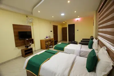 a hotel room with two beds and a television at Builda Park inn in Ottappālam
