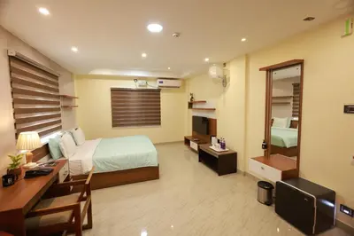 a bedroom with a bed and a desk and a television at Builda Park inn in Ottappālam
