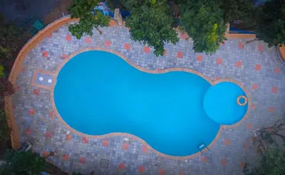 an overhead view of a swimming pool with blue water at My Village - Eco Rural Resort in Coimbatore