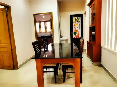 a dining room with a glass table and chairs at Thrissur Villas Home Stay in Trichūr