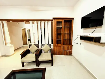 a living room with two chairs and a television at Thrissur Villas Home Stay in Trichūr