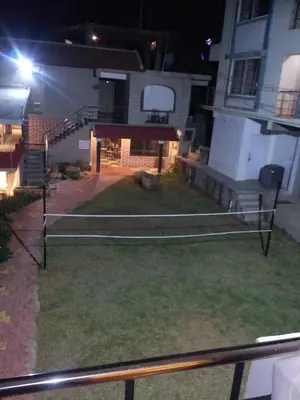 a view of a house at night with a volleyball court at The Meadows in Kodaikānāl