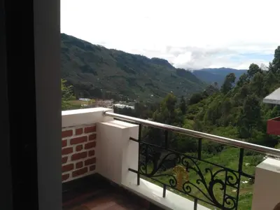 a balcony with a view of the mountains at The Meadows in Kodaikānāl