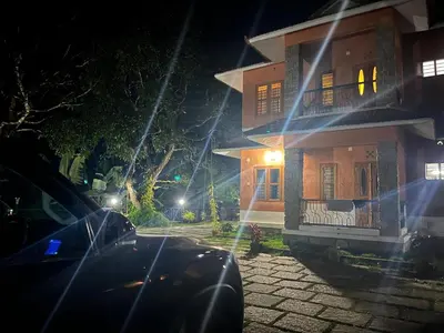 a car parked in front of a house at night at Chembra Adobe in Kalpetta