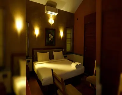 a bedroom with a bed with white sheets and pillows at Chembra Adobe in Kalpetta