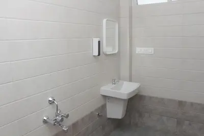 a white bathroom with a sink and a mirror at Grand Misty Heaven in Madikeri