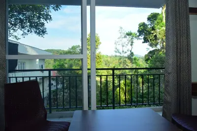 a room with a window with a view of a balcony at Grand Misty Heaven in Madikeri