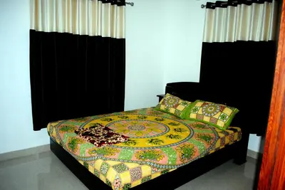 a bed with a colorful blanket and pillows on it at NICE VILLA in Irimbranallūr