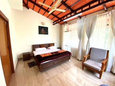 a bedroom with a bed and a chair in it at LAZY DAYS Wayanad in Cherambādi