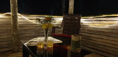 a table with a chair and a vase of flowers at LAZY DAYS Wayanad in Cherambādi
