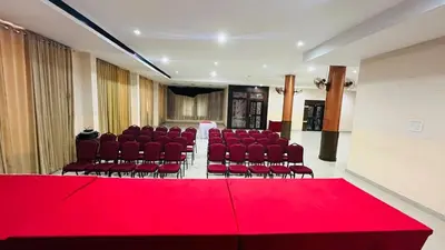 a room with a red table and chairs and a red carpet at KPM Regency in Palakkad
