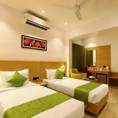 a hotel room with two beds with green sheets at Park Residency Kodungallur in Trichūr