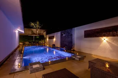 a large swimming pool with lights in a building at Tuskers Hill by Poppys Anaikatti in Palghat