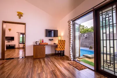 an open living room with a view of a pool at Tuskers Hill by Poppys Anaikatti in Palghat