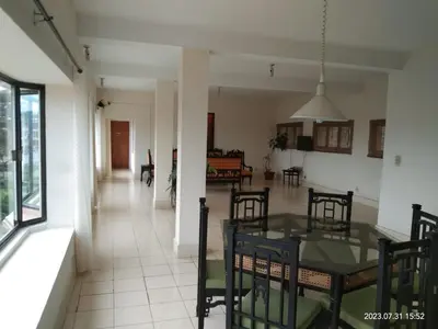 a dining room and living room with a table and chairs at Camellia Heights 1&2 in Coonoor