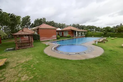 a backyard with a swimming pool and a gazebo at vihangama Home Stay in Chāmundi