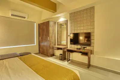 a bedroom with a bed and a tv and a mirror at AS AIRPORT Inn in Cochin