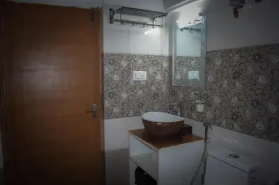 a bathroom with a sink and a wooden door at Ibni Springs in Madikeri