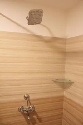 a bathroom with a shower with a glass wall at Aura Residency in Trichūr