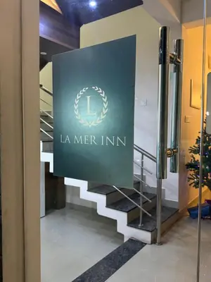 a sign for the l ne mer inn in a lobby at La Mer Inn in Kozhikode