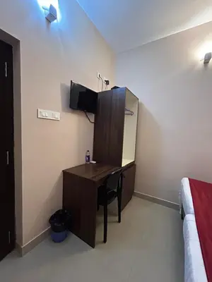 a desk in a room with a bed and a desk in a bedroom at La Mer Inn in Kozhikode