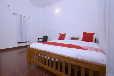 a bedroom with a large bed with red pillows at Wayal Wayanad Farm Resort in Panamaram