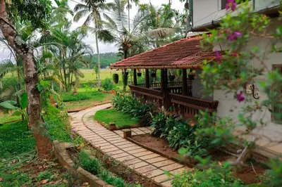 a garden with a small building and a walkway at Wayal Wayanad Farm Resort in Panamaram