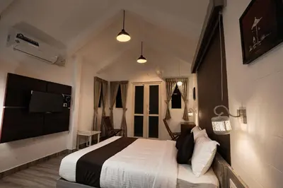 a bedroom with a bed and a flat screen tv at IRON BRIDGE COVE in Meppādi