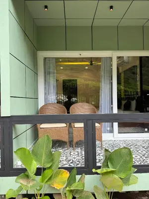 a balcony with chairs and a table with plants at IRON BRIDGE COVE in Meppādi
