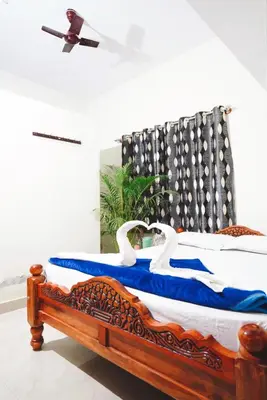 a bedroom with a bed with swans on it at Coorg peacock feathers home stay in Kushālnagar