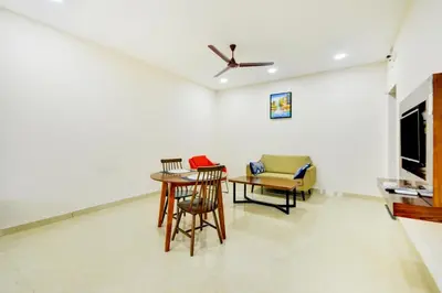 a dining room with a table and chairs at Mayfair Service Apartments in Pīlamedu