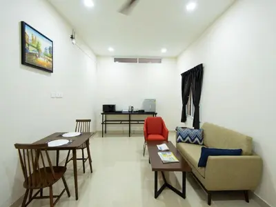 a living room with a couch and a table at Mayfair Service Apartments in Pīlamedu