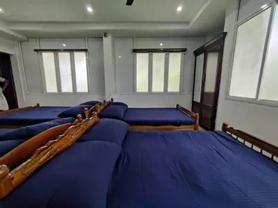 a row of blue pillows in a room with windows at Fresh Up In Guruvayur Krishnendhu Residency in Guruvāyūr