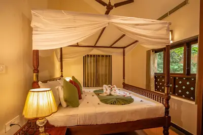 a bedroom with a canopy bed with two dolls on it at Vythiri Mist Resort in Vythiri