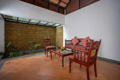a living room with two chairs and a couch at Vythiri Mist Resort in Vythiri