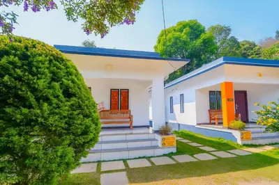 a small white house with a blue roof at Vythiri Silver Mist Hilltop Villa By VOYE HOMES in Vythiri