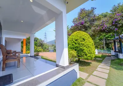 a view from the porch of a house with a chair at Vythiri Silver Mist Hilltop Villa By VOYE HOMES in Vythiri
