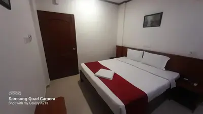 a bedroom with a bed with a red and white blanket at Sayoojyam Residency in Palakkad