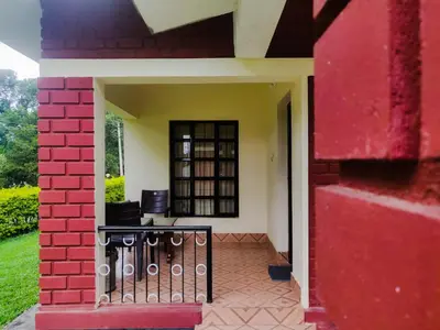 an outside view of a house with a red wall at Dubare Inn Coorg in Madikeri