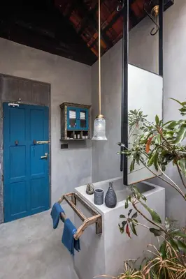 a room with a blue door and a table with vases at Periyar River Lodge in Thattakād