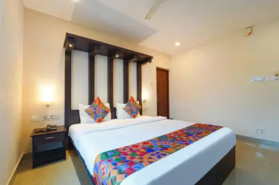 a bedroom with a large bed with a colorful blanket at Zion Plaza in Nedumbassery
