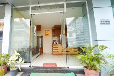 a glass entrance to a building with potted plants at Zion Plaza in Nedumbassery