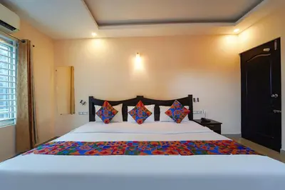 a bedroom with a large white bed with pillows at Zion Plaza in Nedumbassery