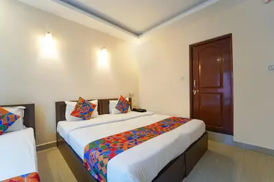 a bedroom with a large bed and a wooden door at Zion Plaza in Nedumbassery