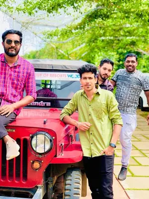a group of men standing on the front of a red truck at CHILLAX Resorts Palakkayam THATTU in Paithalmala