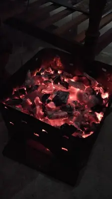 a grill with a red fire in it at Aiyappa Stays in Madikeri
