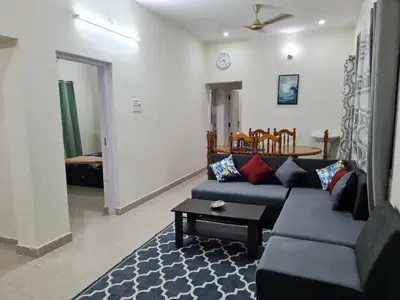 a living room with a blue couch and a table at Happy Home in Coimbatore