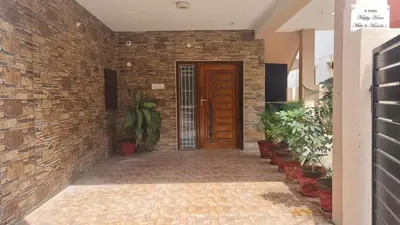 a brick hallway with a wooden door and plants at Happy Home in Coimbatore