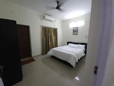 a bedroom with a white bed and a window at Happy Home in Coimbatore
